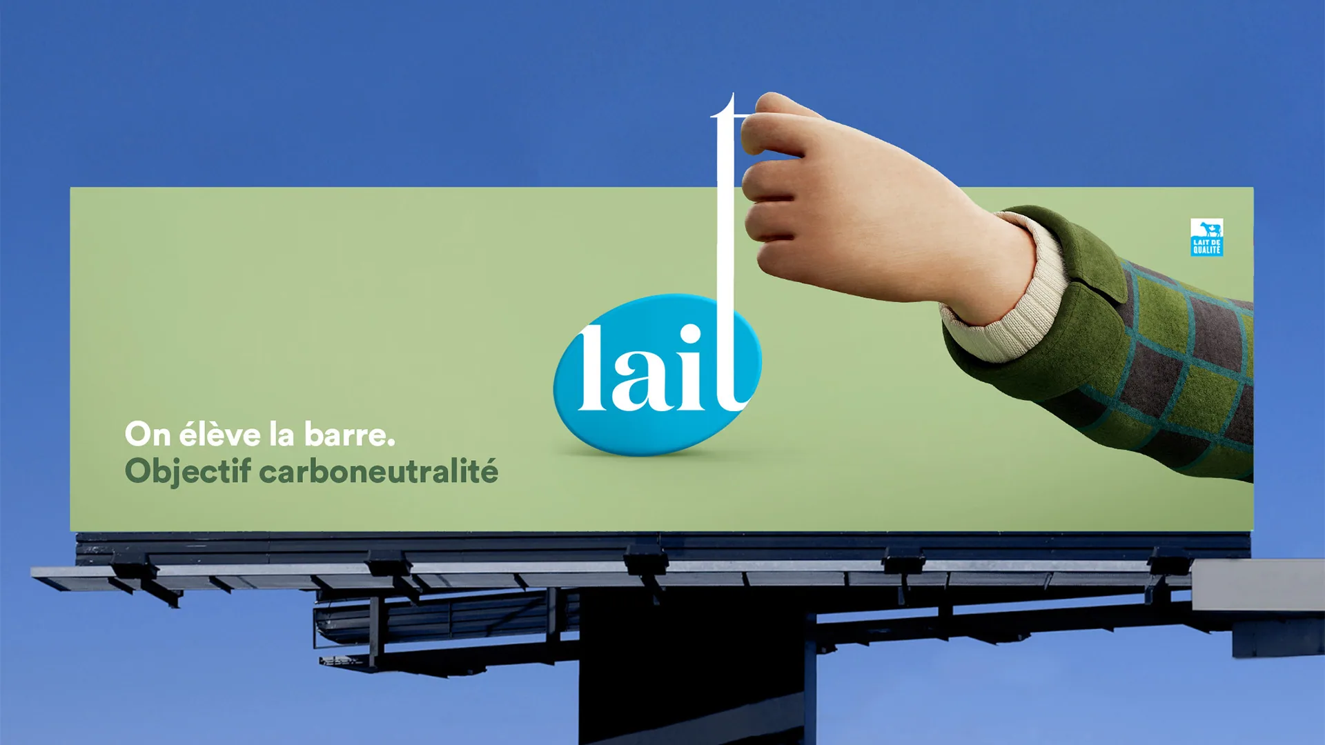 Billboard: a hand raising a bar above the lait logo, “On élève la barre. Objectif carboneutralité”