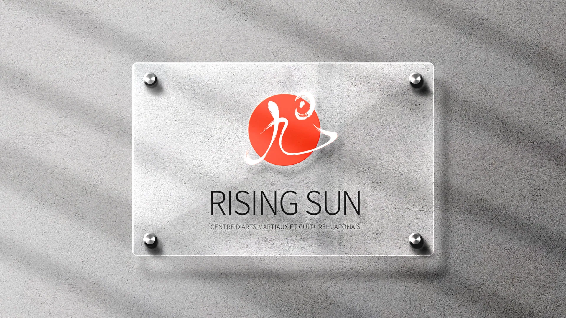 Rising Sun logo, a red kanji emblem, on a glass plaque mounted on a wall
